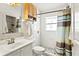 Cozy bathroom featuring a shower with a striped curtain and a light wood cabinet at 3414 Willow Branch Ln, Kissimmee, FL 34741