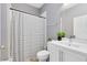 Well-lit bathroom featuring a sleek vanity with a bright mirror and a shower with a striped curtain at 3431 Perching Rd, St Cloud, FL 34772