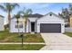 Inviting single-story home with palm trees, a dark garage door, and a well-kept front lawn at 3431 Perching Rd, St Cloud, FL 34772