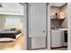 Hallway view with a laundry room with machines and a bedroom with tray ceiling detail at 3431 Perching Rd, St Cloud, FL 34772