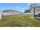 Spacious, green backyard enclosed by a white fence, perfect for outdoor activities at 3642 Doe Run Dr, St Cloud, FL 34772