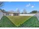 Expansive fenced backyard with healthy green grass and a view of the house at 3642 Doe Run Dr, St Cloud, FL 34772