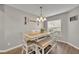 Bright dining room with a light wood table, bench seating, and stylish chandelier at 3642 Doe Run Dr, St Cloud, FL 34772