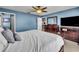 Spacious main bedroom with blue walls, dark wood furniture, and a large window at 3642 Doe Run Dr, St Cloud, FL 34772