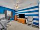 Office space with blue and white striped walls and a dark wood desk at 3642 Doe Run Dr, St Cloud, FL 34772