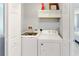 Efficient laundry room boasts a washer, dryer, and convenient overhead storage cabinets at 3939 Calabria Ave, Davenport, FL 33897