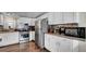 Well-lit kitchen featuring stainless steel appliances, wood floors, and white cabinetry at 415 N Winter Park Dr, Casselberry, FL 32707