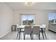 Chic dining room with modern table and chairs, large windows overlooking the backyard and an adjacent living room at 417 Noble Ave, Davenport, FL 33837