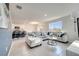 Spacious living room featuring a large sectional sofa, tile floors, kitchen bar and bright windows at 417 Noble Ave, Davenport, FL 33837