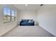 Living room with comfortable blue sofa, bright window, and neutral carpet at 417 Noble Ave, Davenport, FL 33837