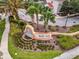 Community entrance sign at Bella Vida with tropical landscaping and decorative water feature at 4506 Alberto Cir, Kissimmee, FL 34746