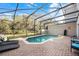 Screened-in pool area with brick pavers and outdoor seating, surrounded by trees at 4506 Alberto Cir, Kissimmee, FL 34746