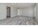 Spacious bedroom with gray wood-look floors, neutral walls, and walk-in closet at 4628 Chicadee Ave, Orlando, FL 32812