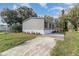 Home exterior with fresh landscaping, a new driveway, and gray vinyl siding at 4628 Chicadee Ave, Orlando, FL 32812