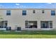 Back exterior view featuring a green lawn and patio entrances to the townhome's rear living spaces at 4846 Coral Castle Dr, Kissimmee, FL 34746