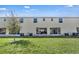 Townhome backyard view shows the green lawn and rear exterior with windows and patio doors at 4846 Coral Castle Dr, Kissimmee, FL 34746