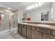 Bathroom featuring a double sink vanity, large mirror, and walk-in shower with glass doors at 4846 Coral Castle Dr, Kissimmee, FL 34746