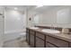 This bathroom is nicely equipped with double sinks, tub, and bright lighting at 4846 Coral Castle Dr, Kissimmee, FL 34746
