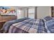 This is a bright and airy bedroom with large window and a plush blue plaid comforter at 4846 Coral Castle Dr, Kissimmee, FL 34746