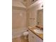 Well-lit bathroom featuring a granite countertop vanity, tiled shower, and white fixtures at 5116 Conroy Rd # 12, Orlando, FL 32811