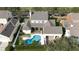 An aerial view of a spacious property featuring a sparkling blue pool and attached garage at 614 Golfpark Dr, Kissimmee, FL 34747