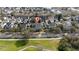 An aerial view of a residential neighborhood near green spaces and a well-maintained street at 614 Golfpark Dr, Kissimmee, FL 34747