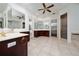 Spacious bathroom boasts tile flooring, a large mirror, and dark wood cabinets at 614 Golfpark Dr, Kissimmee, FL 34747