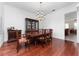 Formal dining room with wood floors, a large table, chairs, chandelier, and a china cabinet for elegant entertaining at 614 Golfpark Dr, Kissimmee, FL 34747