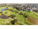 Scenic aerial view of a lush golf course with mature trees, winding paths, and serene water features at 614 Golfpark Dr, Kissimmee, FL 34747