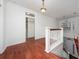 Upstairs hallway with hardwood floors, white railings, and views of the foyer at 614 Golfpark Dr, Kissimmee, FL 34747