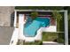 Aerial view of a private pool and jacuzzi surrounded by a white fence and manicured landscaping at 614 Golfpark Dr, Kissimmee, FL 34747