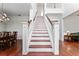 Bright entryway showcases a beautiful wood staircase with white risers and banisters, with wood floors and dining to the left at 614 Golfpark Dr, Kissimmee, FL 34747