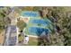 Aerial view of well-maintained community tennis courts with lighting, benches, and convenient parking at 614 Golfpark Dr, Kissimmee, FL 34747