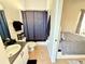 This bathroom features a shower with a black shower curtain next to a bedroom with a queen bed at 650 Tuscan Hills Blvd, Davenport, FL 33897