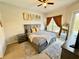 A bedroom with a large bed and a window, complemented by matching nightstands and a ceiling fan at 650 Tuscan Hills Blvd, Davenport, FL 33897