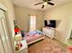 A bedroom featuring a twin bed, white dresser with TV, a window, and ceiling fan at 650 Tuscan Hills Blvd, Davenport, FL 33897