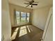 An empty bedroom featuring three windows, tan carpet, and ceiling fan at 650 Tuscan Hills Blvd, Davenport, FL 33897