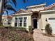 Welcoming front entrance with a dark blue door, manicured bushes, and brick pathway at 650 Tuscan Hills Blvd, Davenport, FL 33897