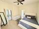 Bright main bedroom featuring a ceiling fan, a modern dresser and ensuite bathroom with a door to a large lanai at 650 Tuscan Hills Blvd, Davenport, FL 33897