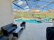 Screened-in pool area with comfortable seating, a spa and well-manicured hedges at 650 Tuscan Hills Blvd, Davenport, FL 33897