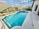 Sparkling pool in screened lanai featuring a spa and two turquoise chairs at 650 Tuscan Hills Blvd, Davenport, FL 33897