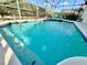 Clear, blue pool with a spa and two turquoise chairs in a screened-in lanai at 650 Tuscan Hills Blvd, Davenport, FL 33897