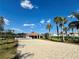 Sandy volleyball court with the community playground and houses in the background at 650 Tuscan Hills Blvd, Davenport, FL 33897