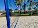 Sandy volleyball court with palm trees and the net in the foreground at 650 Tuscan Hills Blvd, Davenport, FL 33897