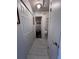 Hallway with closet space leading to the bathroom, featuring neutral tile flooring at 710 E Arizona Ave # A, Deland, FL 32724