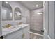 Bathroom with double vanity, framed mirrors, and tiled shower at 713 Greenleaf Ln, Lake Wales, FL 33853