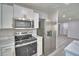 Well-lit kitchen features stainless steel appliances, white cabinetry and marble countertops at 713 Greenleaf Ln, Lake Wales, FL 33853