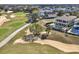 Two-story home backs onto a golf course featuring a pool, patio, and lush lawn at 7471 Gathering Loop, Reunion, FL 34747