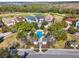 Aerial shot showcases a community pool area surrounded by lush trees and well-maintained houses at 7471 Gathering Loop, Reunion, FL 34747