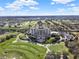 An aerial view showcases a resort surrounded by lush golf greens and perfectly manicured lawns at 7471 Gathering Loop, Reunion, FL 34747